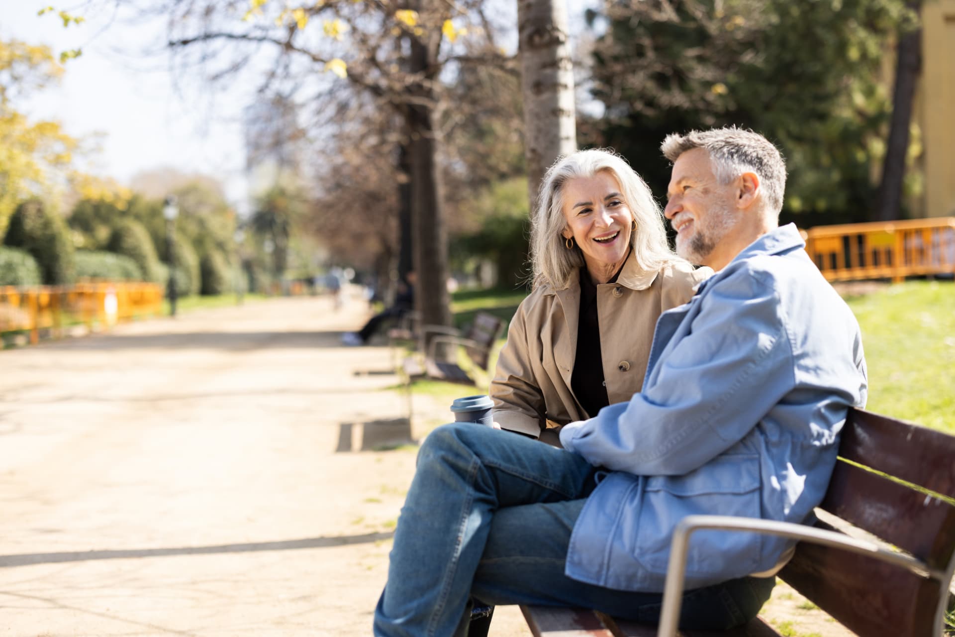 Mature couple enjoying a sunny day on a park bench